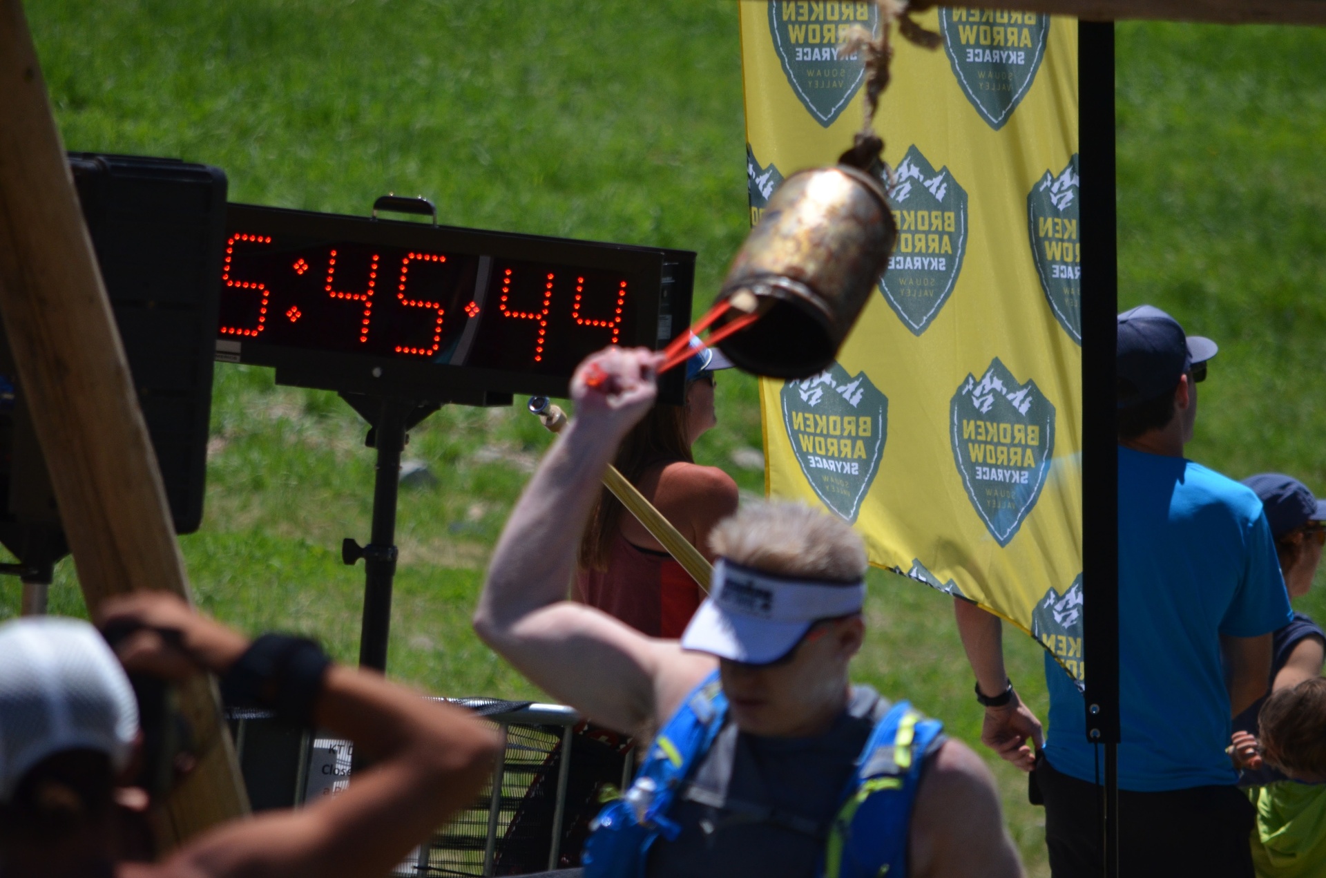 Ringing the finisher's cowbell myself at the Broken Arrow Skyrace, 5:45:44 on the clock. The tradition: you mark your own arrival.